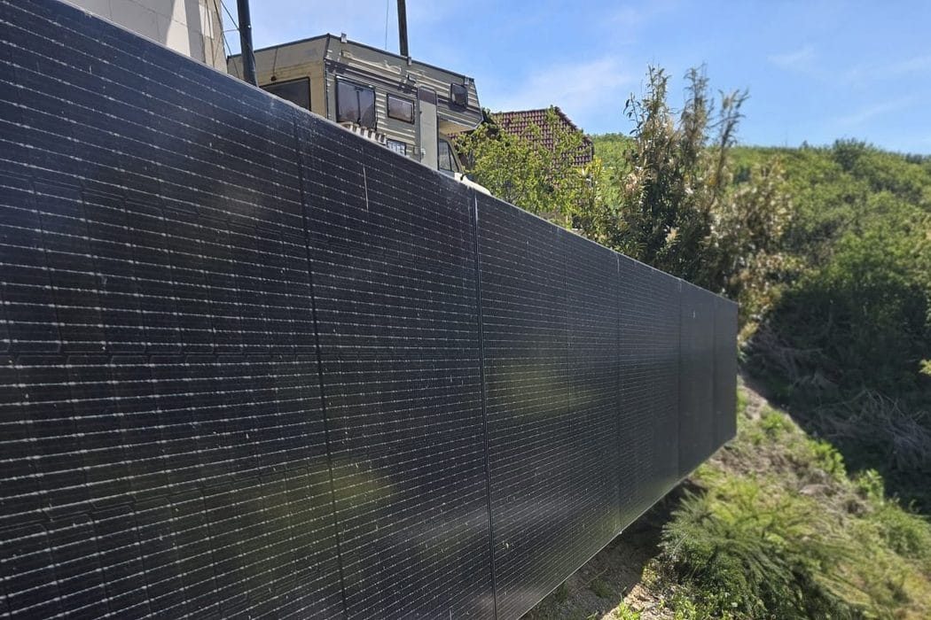 Solarna ograja iz črnih panelov ob brežini